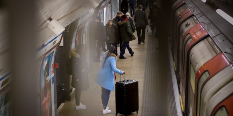 A smiling woman boarding a Eurostar train at St Pancras International, ready for one of the best city breaks from London