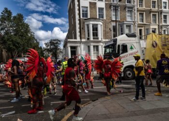 A woman in a colourful costume dancing at the Notting Hill Carnival during the bank holiday weekend in London