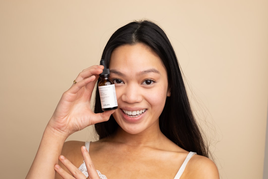 A woman holding a sustainable moisturiser bottle as part of her minimal skincare routine from a London independent brand