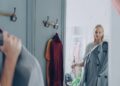 woman-sorting-clothes-wardrobe-unsplash - LONDONwebzine A woman reviewing her London wardrobe items on a bed, preparing for a seasonal transition from summer to autumn