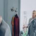 woman-sorting-clothes-wardrobe-unsplash - LONDONwebzine A woman reviewing her London wardrobe items on a bed, preparing for a seasonal transition from summer to autumn
