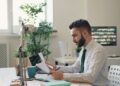 businessman-reviewing-property-documents-auction-unsplash - LONDONwebzine A focused investor reviews a legal pack before participating in commercial auctions in London