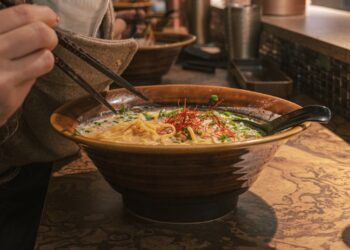 A chef ladles rich tonkotsu broth into a bowl at one of London's top ramen restaurants