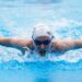 lap-swimming-unsplash - LONDONwebzine A woman in a wetsuit preparing to enter a London reservoir for open water swimming at dawn