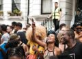 nigerian-woman-london-unsplash - LONDONwebzine A visitor from London's Nigerian community standing before a painting at a major art exhibition