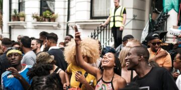 nigerian-woman-london-unsplash - LONDONwebzine A visitor from London's Nigerian community standing before a painting at a major art exhibition