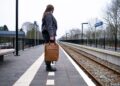 woman-arriving-train-station-platform-unsplash - LONDONwebzine A woman steps off a train at a historic British station platform, ready to begin one of her weekend escapes from London.