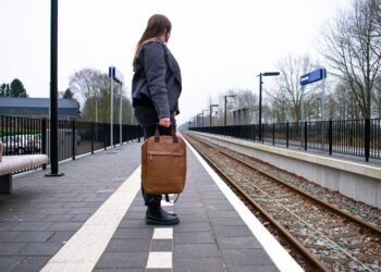 Une femme descend d'un train sur le quai d'une gare historique britannique, prête à entamer l'une de ses escapades de week-end au départ de Londres.