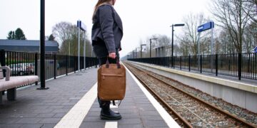 woman-arriving-train-station-platform-unsplash - LONDONwebzine A woman steps off a train at a historic British station platform, ready to begin one of her weekend escapes from London.