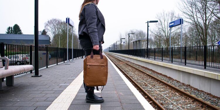 woman-arriving-train-station-platform-unsplash - LONDONwebzine A woman steps off a train at a historic British station platform, ready to begin one of her weekend escapes from London.