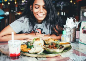 Une femme partageant un plateau d'injera dans un restaurant éthiopien avec des amis à Londres