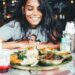 woman-eating-injera-platter-unsplash - LONDONwebzine A woman sharing an Ethiopian restaurants injera platter at a table with friends in London