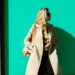 woman-layering-clothes-autumn-london-street-unsplash - LONDONwebzine A woman layering clothes on a London street in early autumn, adding a knit mid-layer over a merino base outside.