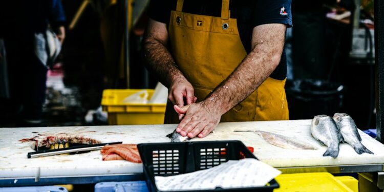 Brixton Market a Caribbean shoppers route photo 1 - LONDONwebzine Fishmonger serving a customer at Brixton Market's Electric Avenue stalls