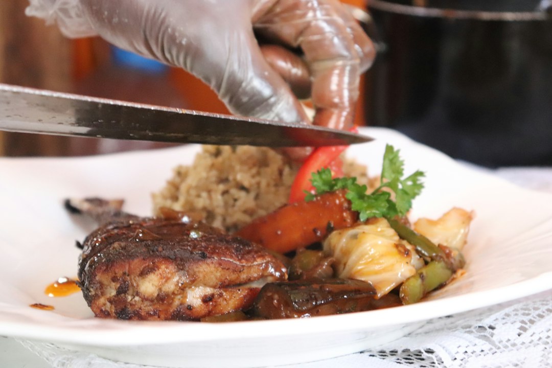 Chef plating jerk chicken at a Brixton Market Caribbean kitchen