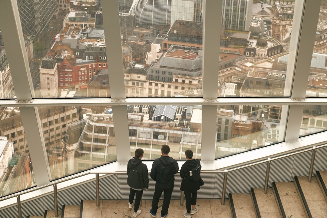 Una pareja visitando una propiedad residencial con un agente inmobiliario, discutiendo el espacio durante una visualización de piso de compra para alquilar en Londres