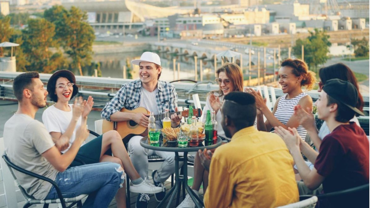 A group of friends enjoying an alfresco lunch on a sunlit terrace in London, raising glasses over a seasonal spread