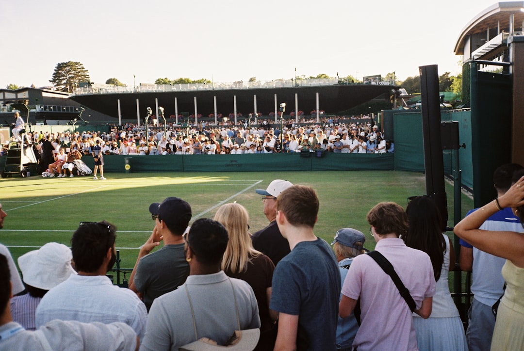 A woman cheering at an outdoor Wimbledon finals screening in central London, surrounded by a summer crowd