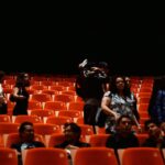 A woman smiles in the audience at the BBC Proms tickets event inside a grand Victorian concert hall