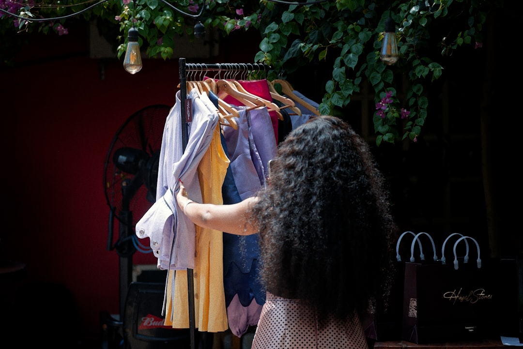 A woman in a linen outfit browsing an independent stall at a London market, building her sustainable wardrobe.