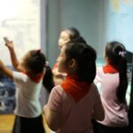 A young girl reaches out to touch a dinosaur fossil display inside one of London's top children's museums