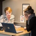 A London finance director conducts a business audit at her office desk in the City, reviewing financial records before Q4.