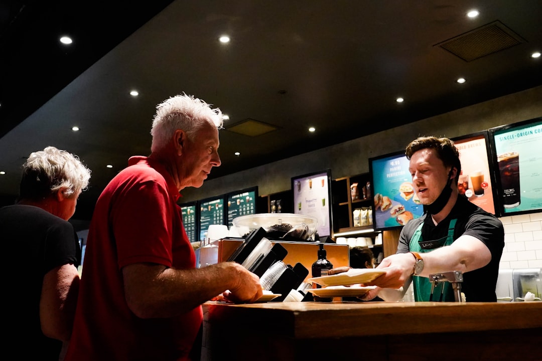 Un uomo che acquista biglietti al bancone di uno dei cinema indipendenti di Londra, sorridendo al membro dello staff