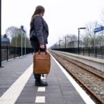 A woman steps off a train at a historic British station platform, ready to begin one of her weekend escapes from London.