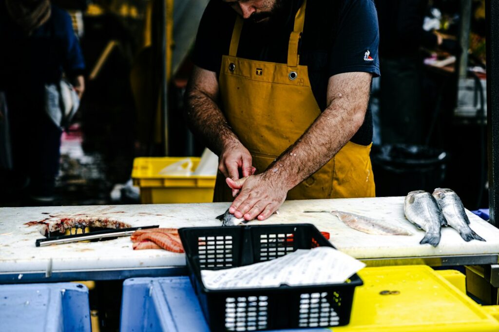 Fishmonger serving a customer at Brixton Market's Electric Avenue stalls